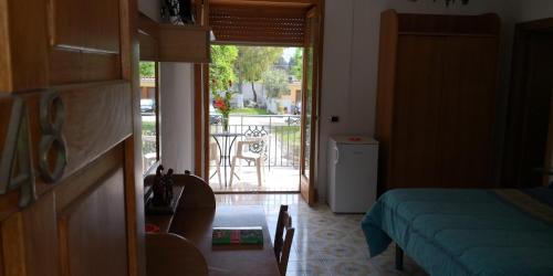 a bedroom with a door open to a patio with a table at Villaggio "Camping Pompei" Bungalow in Pompei
