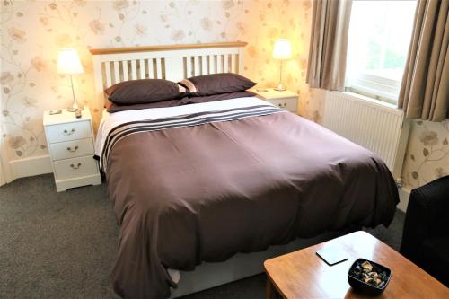 a bedroom with a bed and two night stands and a table at Telford House in Milton Keynes