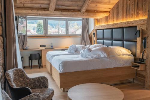 a bedroom with a large bed and a table at Hôtel Interlaken Lounge Bar & Spa in Xonrupt-Longemer