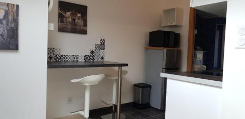 a kitchen with a counter and a stool in a room at joli studio calme coeur de ville in Nancy