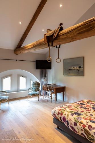 Un dormitorio con una cama y un escritorio en una habitación. en ORANGERIE de CHATEL-Selection FIGARO & ELLE Magazine, en Cleppé