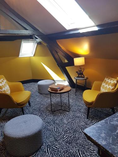 a living room with yellow chairs and a table at La villa 10 HÔTEL SPA in Étretat