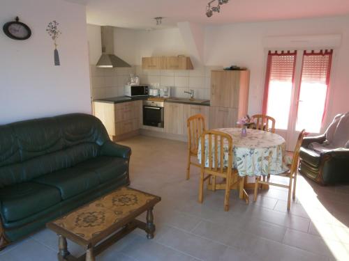 un salon avec un canapé et une table et une cuisine dans l'établissement gitedelaplessardiere, à Crotelles