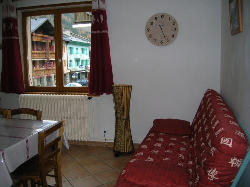 un salon avec un canapé et une horloge au mur dans l'établissement BOROT 3, à Lanslebourg-Mont-Cenis