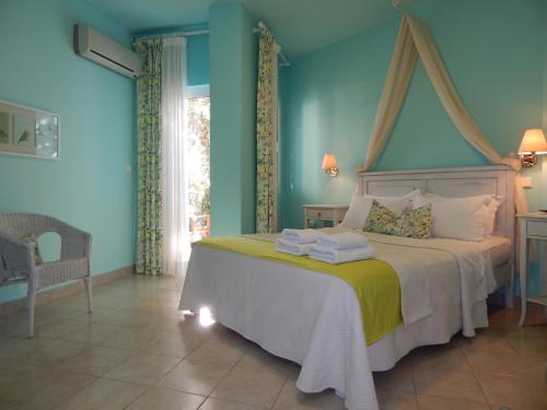 a bedroom with a large bed with blue walls at Palmina Mare Villa and Studios in Paralia Vrachou