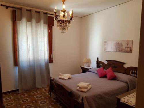 - une chambre avec un lit doté d'oreillers rouges et d'un lustre dans l'établissement A casa di Nonna Giò, à Palerme