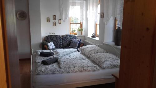 Bett in einem Zimmer mit Sofa und Fenster in der Unterkunft Auszeit in Göstling an der Ybbs