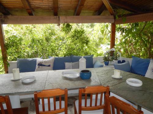 a table with chairs and plates on top of it at Palmina Mare Villa and Studios in Paralia Vrachou