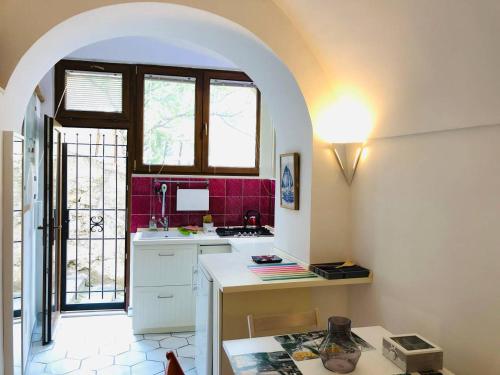 a kitchen with a white counter and red tiles at A casa dei Sasso, Laetitia Suite in Positano