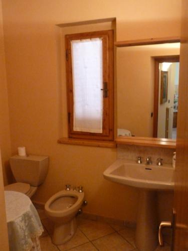 ein Badezimmer mit einem WC, einem Waschbecken und einem Spiegel in der Unterkunft La Casina Appartamento nel Cuore di Greve in Chianti in Greve in Chianti