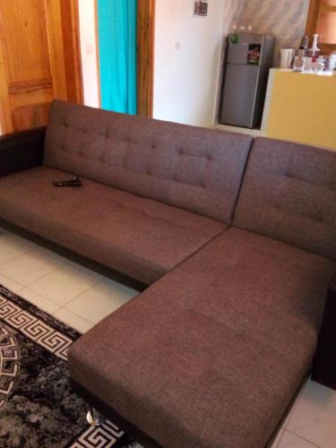 a brown couch sitting in a living room at Chez Coumba et Daniel in Saly Portudal