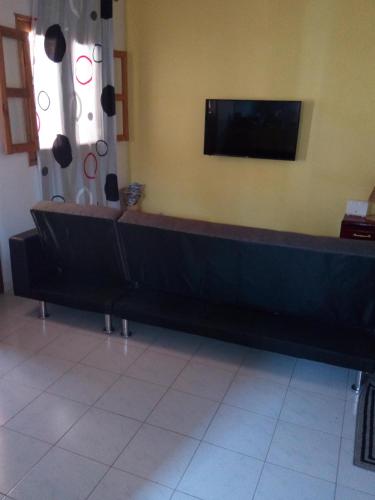 a waiting room with a bench and a flat screen tv at Chez Coumba et Daniel in Saly Portudal