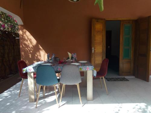 a table with four chairs and a table and a door at Chez Coumba et Daniel in Saly Portudal