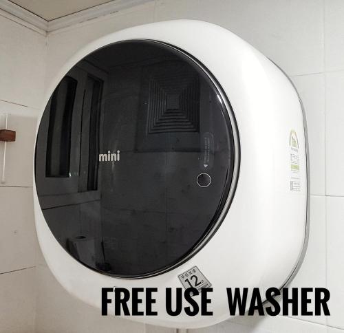 a circular mirror on a wall with a free use washer at Zibro S in Seoul
