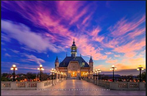 a building with a clock tower on a bridge at sunset at Departamento Alassio in Tigre