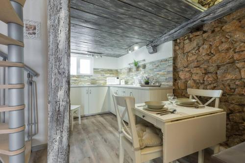 a kitchen with a table and a stone wall at Cannes croisette in Cannes