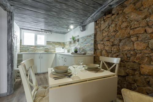 une cuisine avec une table et des chaises et un mur en pierre dans l'établissement Cannes croisette, à Cannes