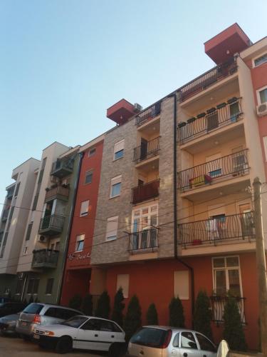 two cars parked in front of a building at Daniris apartman in Novi Sad