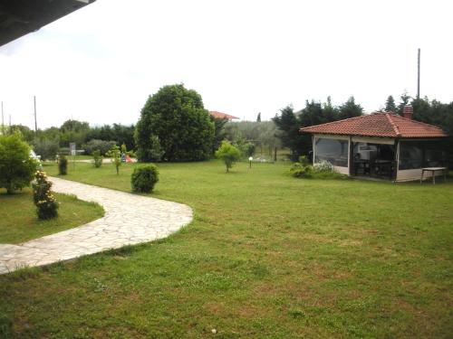 a garden with a house and a walkway at Olympos House in Litochoro