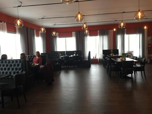 Lille Chili Eat and Sleep AS في Jakobselv: غرفة طعام مع أشخاص يجلسون على الطاولات والكراسي