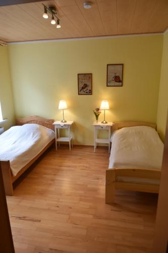 a room with two beds and two lamps on two tables at Ferienwohnung Kaiser Lothar in Süpplingenburg