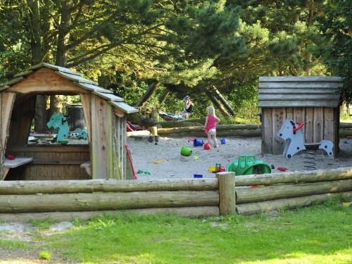a little girl playing in a sandbox in a playground at Rødvig Ferieby in Rødvig