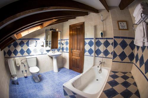 a bathroom with a tub and a toilet and a sink at Trisileja en Puente Romano in Toñanes