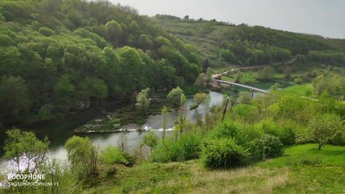 a river with a bridge in the middle of a mountain at SMARAGD RIVER near Rastoke & Plitvice Lakes in Slunj