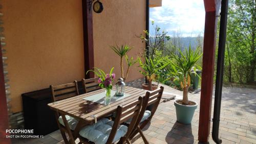 a wooden table and chairs on a patio with plants at SMARAGD RIVER near Rastoke & Plitvice Lakes in Slunj