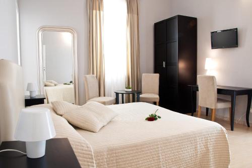 a bedroom with a bed and a desk and a mirror at Operà in Palermo
