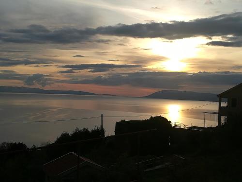 a sunset over a body of water with at Mala Cele in Podgora