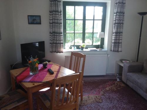 a living room with a table and chairs and a window at Ferienwohnungen Meyer in Bollewick