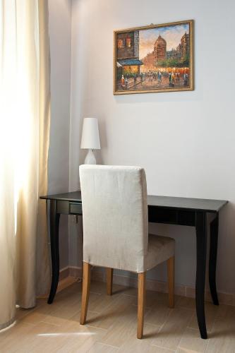 a desk with a white chair next to a table at Operà in Palermo