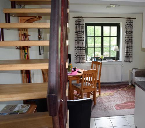 a kitchen and dining room with a table and stairs at Ferienwohnungen Meyer in Bollewick