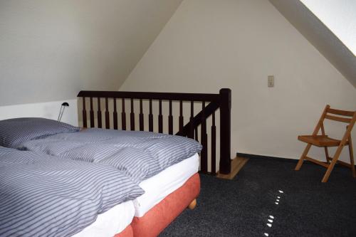 a bedroom with two beds and a chair at Ferienwohnungen Meyer in Bollewick