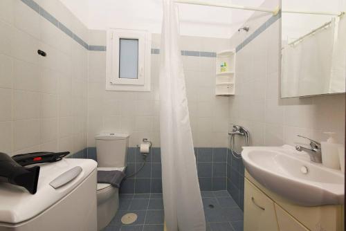 a bathroom with a sink and a toilet and a shower at Aegean View Studio #1 in Azolimnos Syros