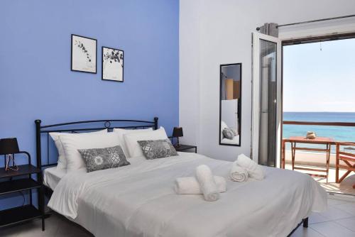 a blue bedroom with a bed with towels on it at Aegean View Studio #1 in Azolimnos Syros