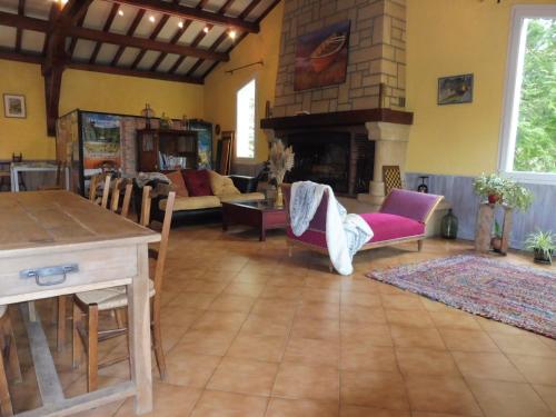 a living room with a couch and a fireplace at Chambres d'Hôtes L'Orée des Bois in Lacrouzette