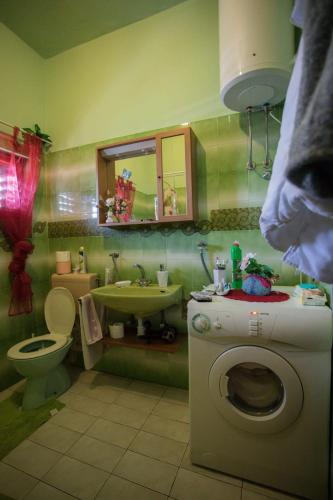 a bathroom with a toilet and a sink and a washing machine at Apartment Fana in Grohote