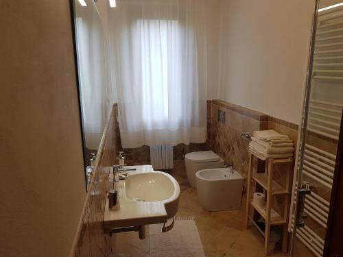 a bathroom with a sink and a toilet and a mirror at Gli Olivi in Calci