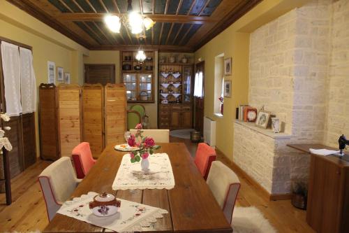 a dining room with a wooden table and chairs at Traditional Guesthouse Marousio in Rodavgi