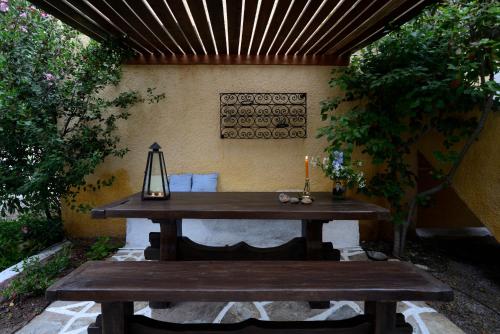 a wooden picnic table with a candle and a bench at Vagia Beach Apartments, Aegina Island in Vaia
