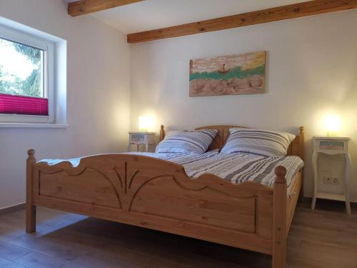 a bedroom with a wooden bed with two night stands at Doppelhaushälfte Nordwind vom Naturhof Usedom in Bannemin