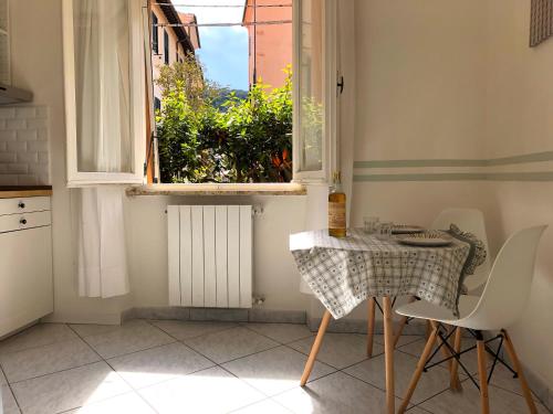 uma mesa e cadeiras numa cozinha com uma janela em Soggiorno Tagliaferro em Marciana Marina