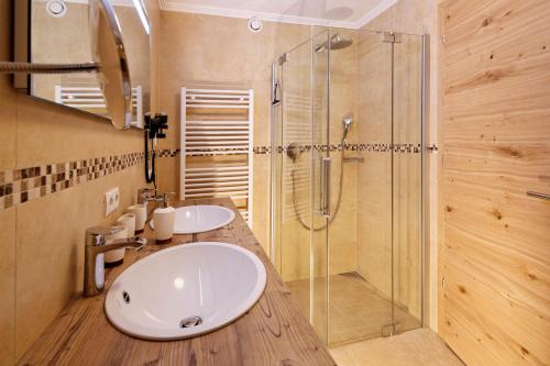 a bathroom with two sinks and a shower at Hotel Berghof in Söll