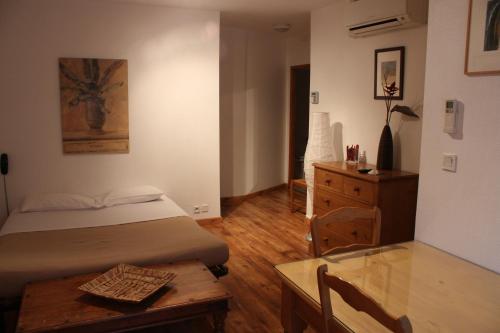 a bedroom with a bed and a table and a desk at Appart Hotel Charles Sander in Salins-les-Bains