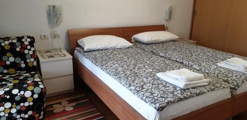 a bedroom with a bed with two pillows and a chair at Apartment Laguna 70 in Izola