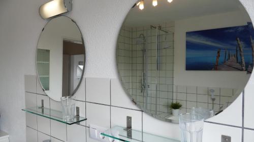 a bathroom with two mirrors and a sink at guest apartment niederalfingen in Hüttlingen