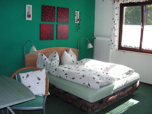 a bedroom with a bed and a green wall at Hotel Sternen in Lenzkirch