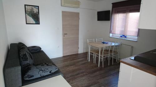a living room and kitchen with a table and a couch at Apartments Barbic in Medulin